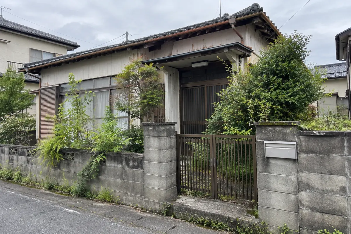 庭木の伸びた古い日本家屋の外観を示す説明用イメージ
