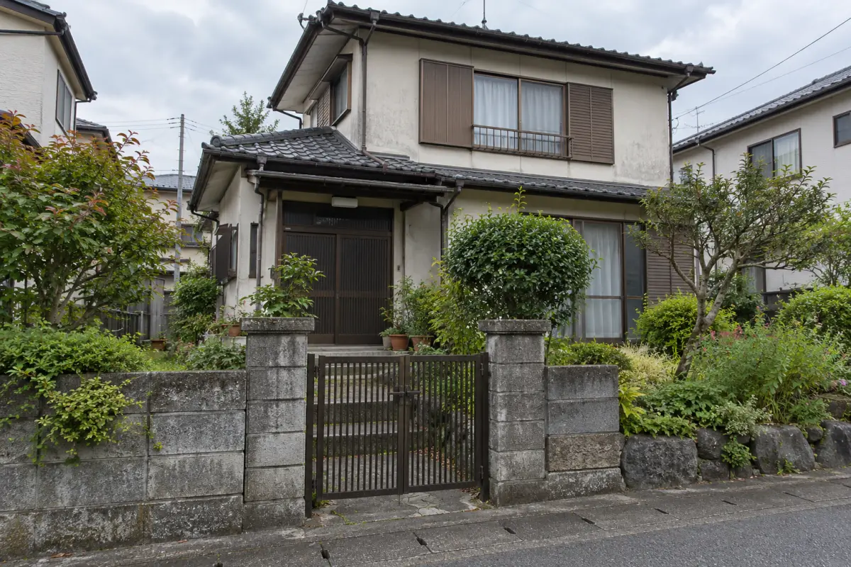 道路から見た古い日本の戸建て住宅と庭、玄関の説明用生成写真