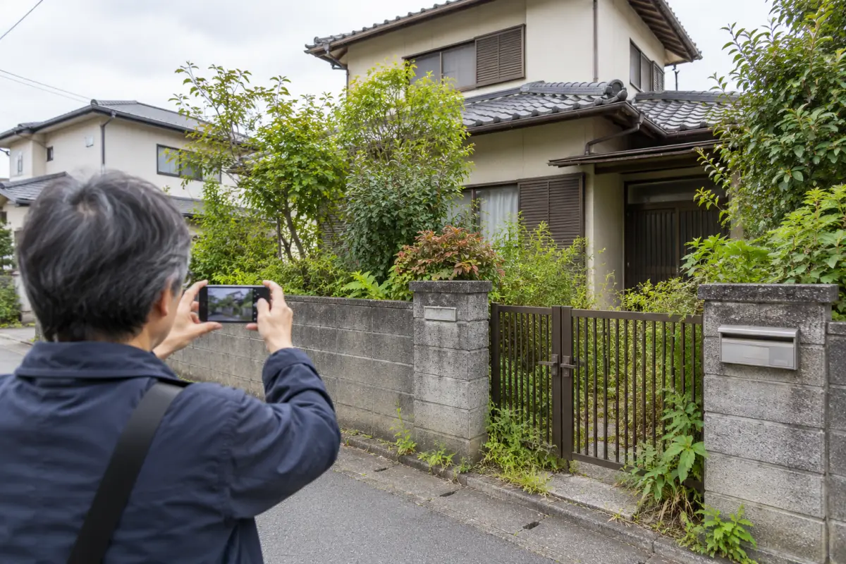 古い家の門扉と玄関を外から記録する様子を描いた生成イメージ