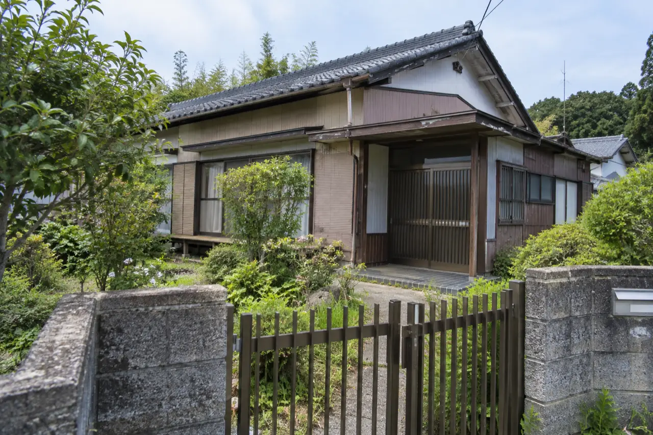 門と庭木のある古い日本の戸建住宅の外観を描いた説明用生成写真