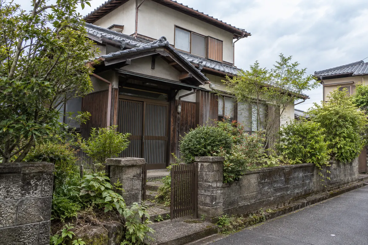 庭木のある古い日本の戸建て住宅を道路側から見た説明用生成写真