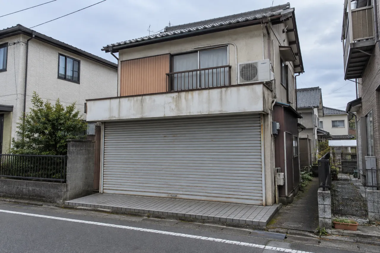 シャッターのある古い日本の店舗兼住宅の外観を描いた説明用生成写真