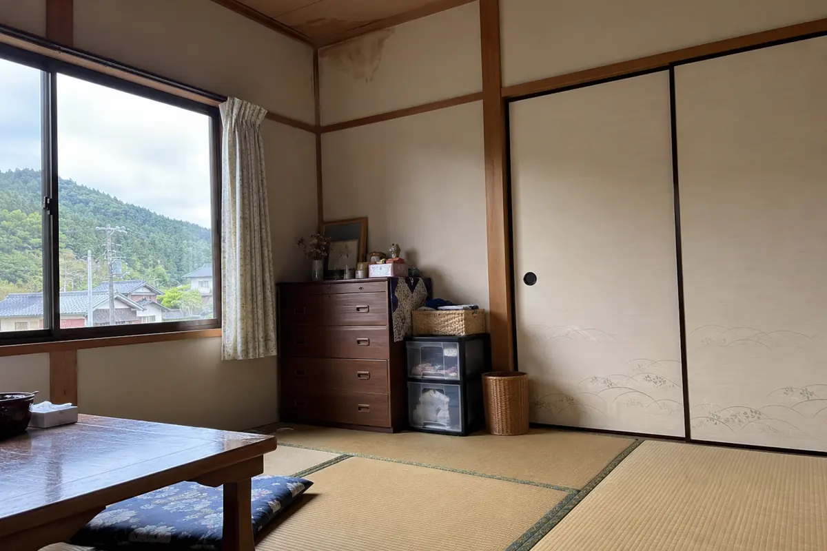 古い日本家屋の畳の部屋に家具と生活用品が残る説明用生成写真